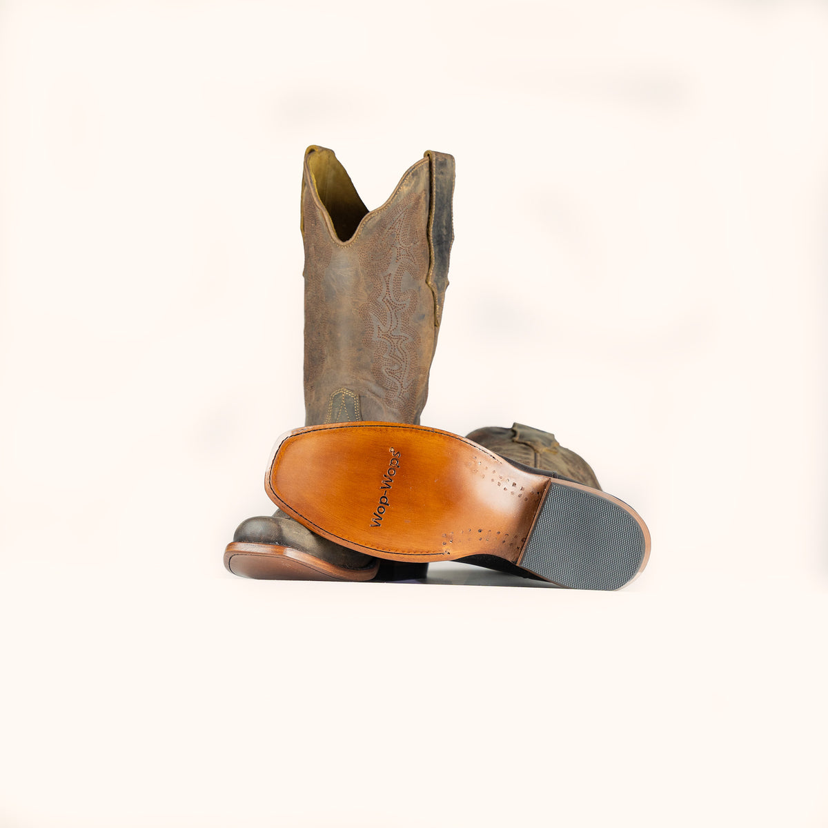 Brown cowboy boot with a visible brand logo on a white background